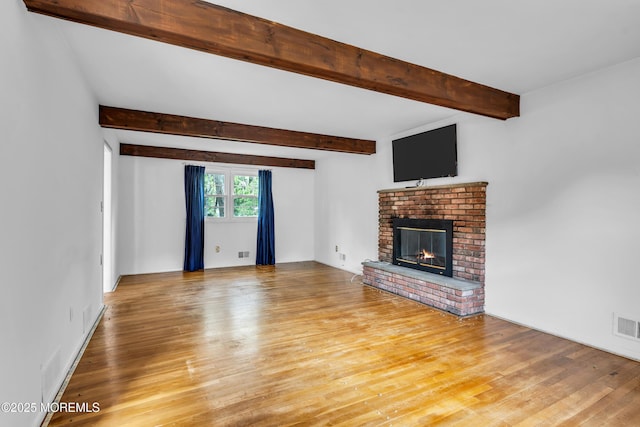 132 Tunes Brook Dr, Brick, NJ 08723 - unfurnished living room featuring light wood finished floors, beam ceiling, and a brick fireplace