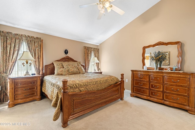 bedroom featuring light colored carpet, vaulted ceiling, and a ceiling fan