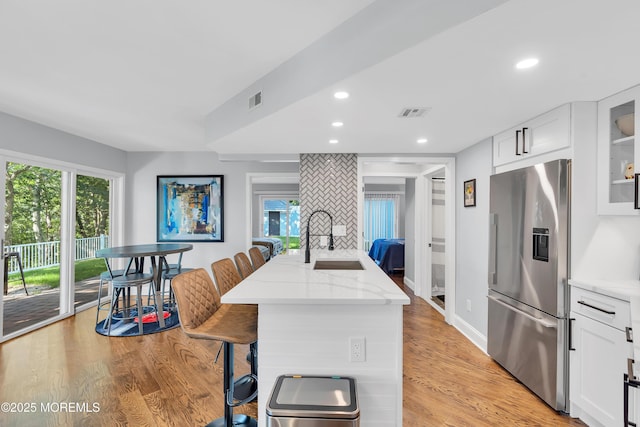 401 Overlook Dr, Neptune Township, NJ 07753 - kitchen with stainless steel fridge with ice dispenser, a sink, light stone countertops, glass insert cabinets, and white cabinetry