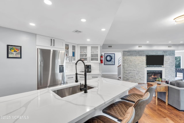 401 Overlook Dr, Neptune Township, NJ 07753 - kitchen featuring stainless steel refrigerator with ice dispenser, a sink, light stone countertops, recessed lighting, and glass insert cabinets