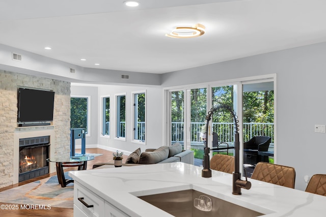 401 Overlook Dr, Neptune Township, NJ 07753 - kitchen featuring light stone countertops, light wood-style flooring, a fireplace, open floor plan, and recessed lighting