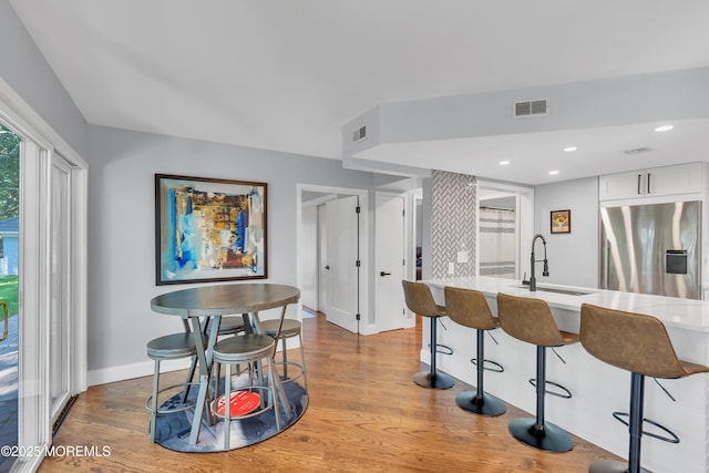 401 Overlook Dr, Neptune Township, NJ 07753 - kitchen featuring stainless steel fridge with ice dispenser, a sink, baseboards, a kitchen bar, and wood finished floors