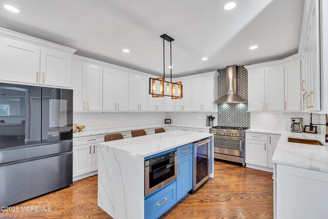 401 Overlook Dr, Neptune Township, NJ 07753 - kitchen with appliances with stainless steel finishes, wall chimney exhaust hood, beverage cooler, blue cabinets, and white cabinets