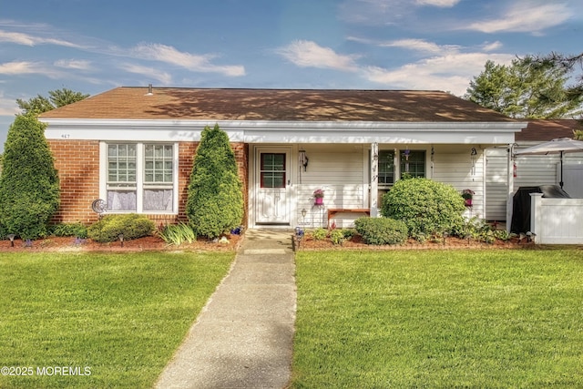 467A Chelsea Ct, Manchester, NJ 08759 - bungalow featuring a front lawn, covered porch, brick siding, and a shingled roof