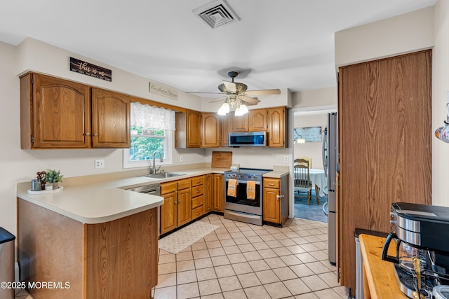 6 Blanche Dr, New Egypt, NJ 08533 - kitchen featuring appliances with stainless steel finishes, a peninsula, a sink, brown cabinetry, and light countertops