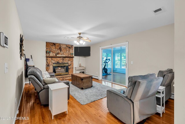 6 Blanche Dr, New Egypt, NJ 08533 - living room with wood finished floors, a ceiling fan, a fireplace, baseboard heating, and a baseboard heating unit
