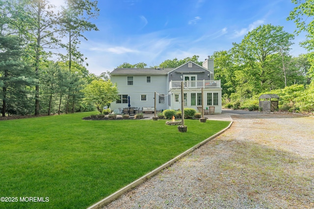 6 Blanche Dr, New Egypt, NJ 08533 - rear view of house featuring driveway, a balcony, a chimney, and a yard