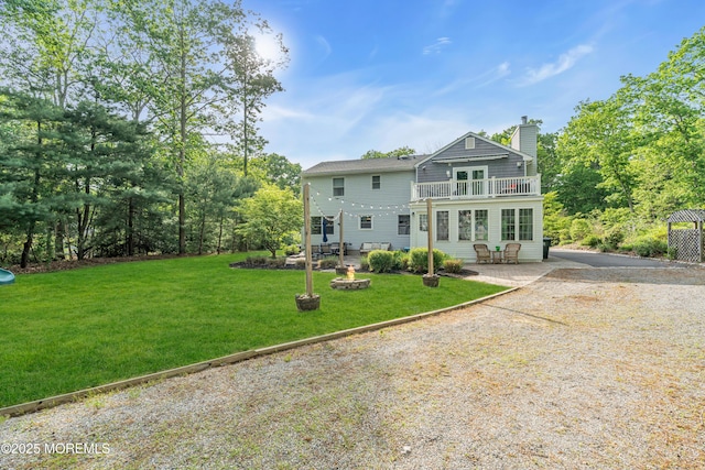 6 Blanche Dr, New Egypt, NJ 08533 - back of property with a balcony, a chimney, a yard, a patio, and gravel driveway