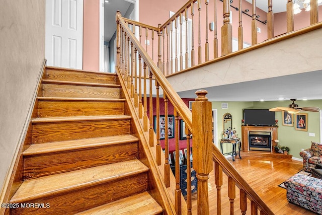 251 Genes Dr, Toms River, NJ 08753 - stairway with a ceiling fan, wood finished floors, a glass covered fireplace, and a high ceiling