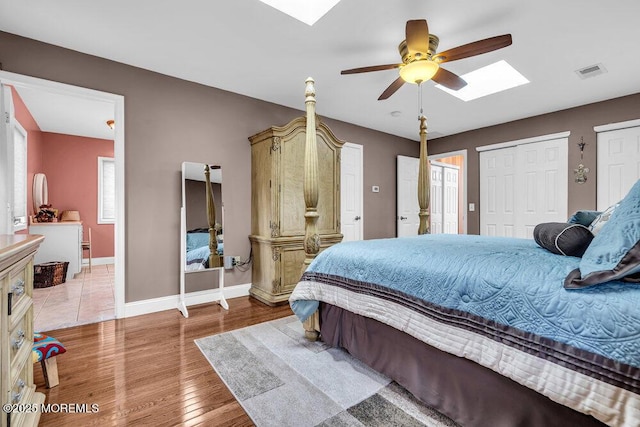 251 Genes Dr, Toms River, NJ 08753 - bedroom featuring a skylight, multiple closets, light wood-style flooring, baseboards, and a ceiling fan