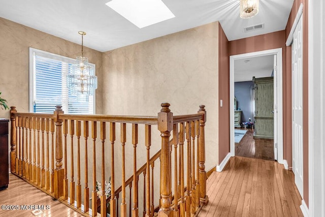 251 Genes Dr, Toms River, NJ 08753 - hall featuring an upstairs landing, hardwood / wood-style floors, a skylight, and a chandelier