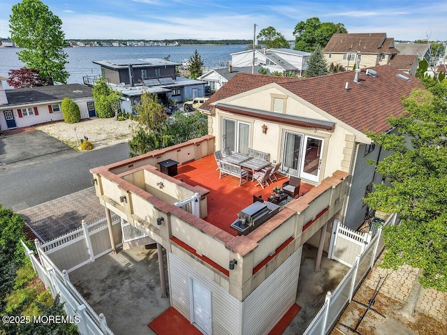 251 Genes Dr, Toms River, NJ 08753 - rear view of house with stucco siding, fence, a water view, and outdoor dining space