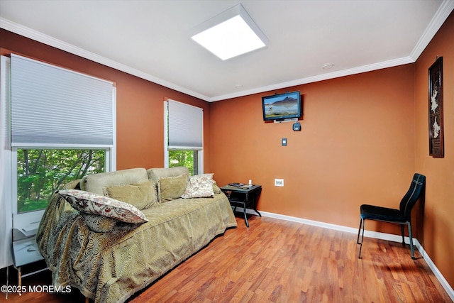 living area featuring wood finished floors, crown molding, and baseboards