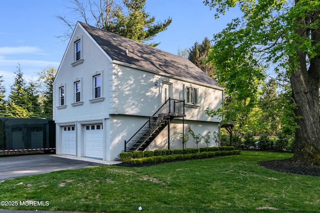 view of home's exterior featuring driveway, a garage, stucco siding, a yard, and roof with shingles