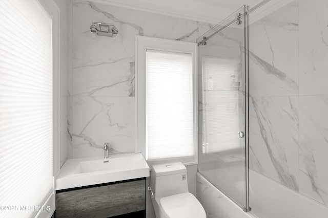 bathroom featuring vanity, toilet, and bath / shower combo with glass door