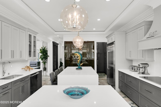 kitchen with a sink, gray cabinets, stainless steel built in fridge, custom exhaust hood, and light countertops
