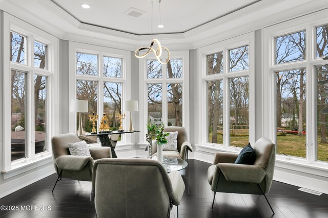 sunroom featuring a chandelier