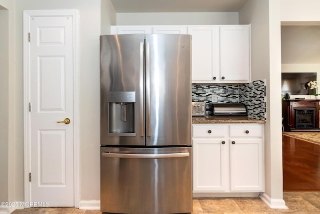 102 Clear Lake Rd, Whiting, NJ 08759 - kitchen featuring stainless steel fridge, white cabinetry, decorative backsplash, dark stone countertops, and baseboards