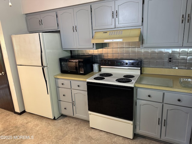 697 Vaughn Ave, Toms River, NJ 08753 - kitchen with under cabinet range hood, range with electric cooktop, black microwave, freestanding refrigerator, and gray cabinetry