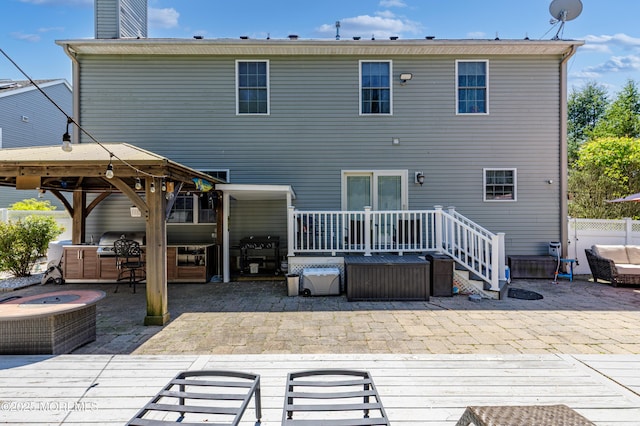 rear view of house featuring a patio, fence, a gazebo, and a wooden deck