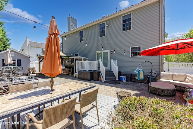 rear view of house featuring an outdoor living space, outdoor dining space, a patio area, and a wooden deck