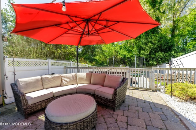 view of patio / terrace featuring an outdoor hangout area, a fenced backyard, and view of scattered trees