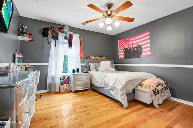 bedroom featuring wood finished floors, a ceiling fan, and baseboards