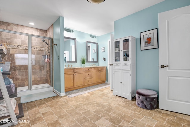 bathroom featuring a stall shower, double vanity, and stone finish floors