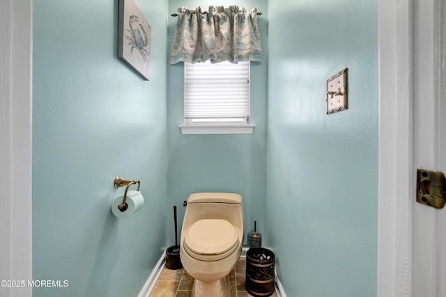 bathroom with baseboards, toilet, and tile patterned floors