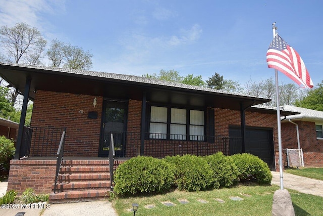 22 Macedulski Ter, South Amboy, NJ 08879 - view of front facade with an attached garage, brick siding, and a porch