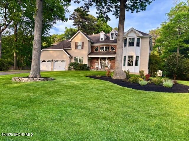 view of front of home with an attached garage, a front yard, and asphalt driveway