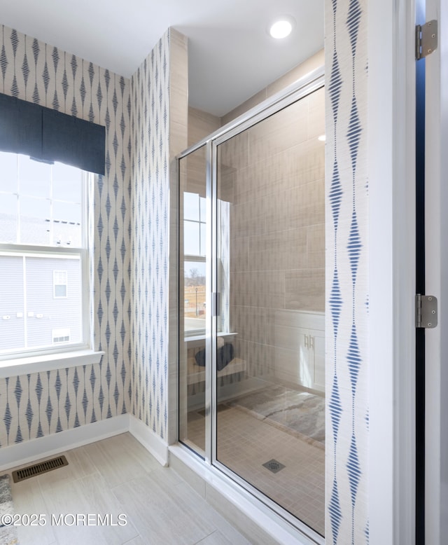 full bathroom featuring wallpapered walls, baseboards, a stall shower, and tile patterned flooring