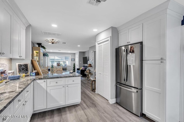 40 Mallard St Unit B, Manchester, NJ 08759 - kitchen with freestanding refrigerator, a peninsula, white cabinetry, light wood-style floors, and light stone counters