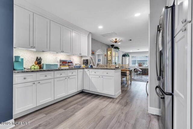 40 Mallard St Unit B, Manchester, NJ 08759 - kitchen with freestanding refrigerator, a peninsula, light wood finished floors, white cabinets, and tasteful backsplash