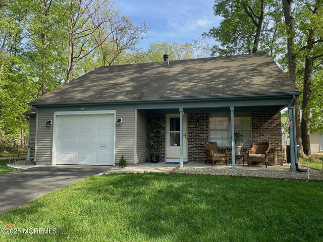 518 Petunia Ln N, Whiting, NJ 08759 - view of front of property featuring a garage, a front lawn, asphalt driveway, brick siding, and covered porch