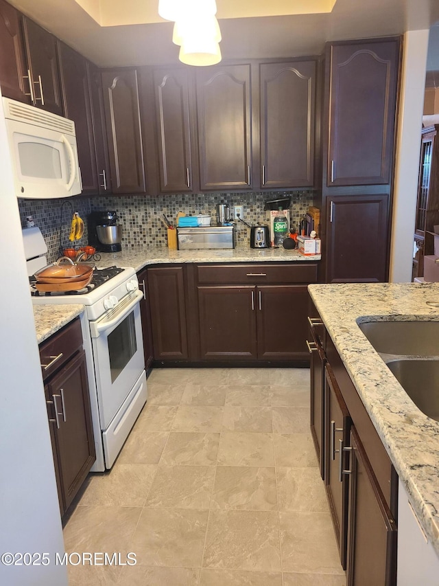 1207A Thornbury Ln Unit A, Manchester, NJ 08759 - kitchen featuring white appliances, decorative backsplash, light stone counters, and dark brown cabinetry