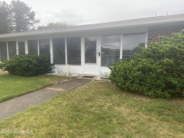 897C Inverness Ct, Lakewood, NJ 08701 - view of side of home with a lawn, brick siding, and a sunroom