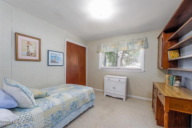 bedroom featuring light colored carpet, a closet, and baseboards