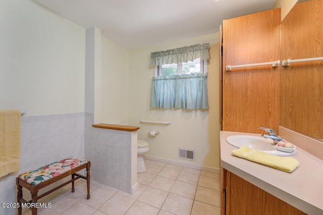 bathroom with toilet, tile patterned floors, vanity, and baseboards
