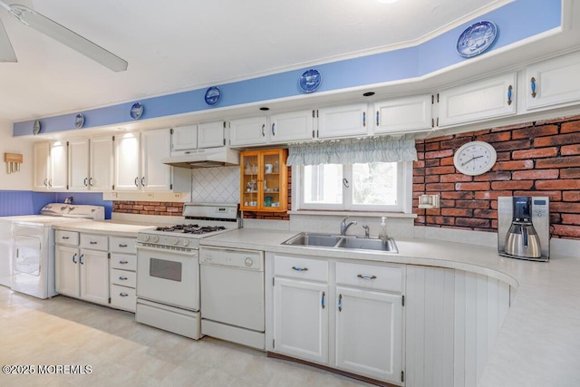 kitchen featuring white appliances, washer / clothes dryer, a sink, under cabinet range hood, and light countertops