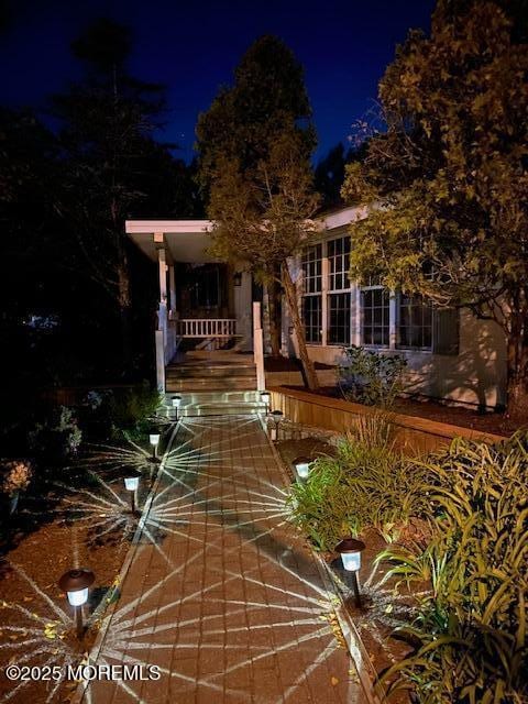 view of property hidden behind natural elements with covered porch