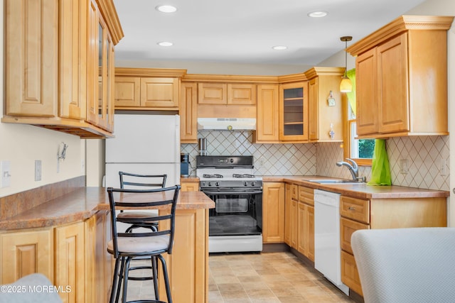 kitchen featuring white appliances, under cabinet range hood, a sink, light brown cabinetry, and recessed lighting