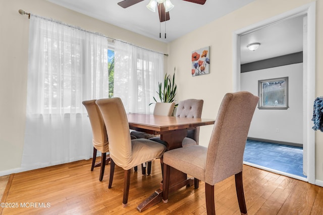 dining area featuring wood finished floors, ceiling fan, and baseboards