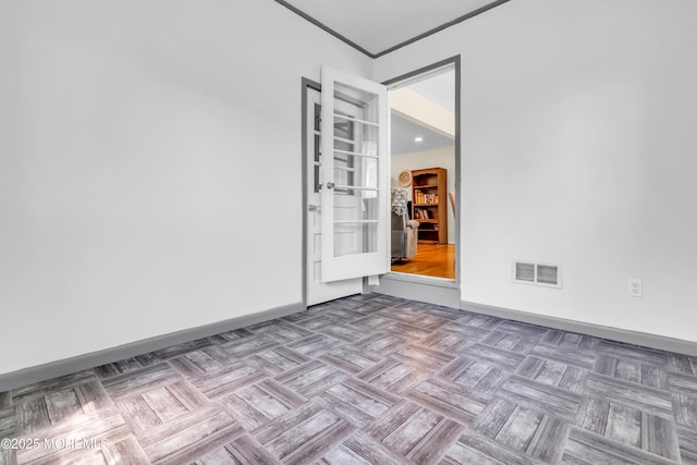 unfurnished room featuring baseboards, crown molding, and french doors