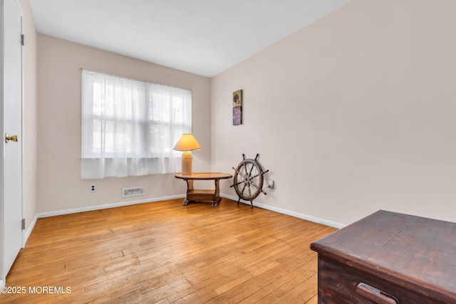 living area with light wood-style flooring and baseboards