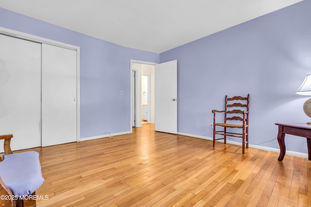 living area with light wood-type flooring and baseboards