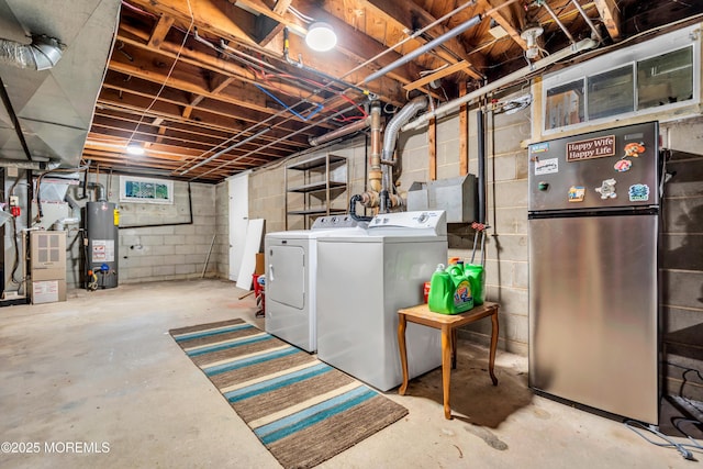 below grade area featuring freestanding refrigerator, water heater, washing machine and clothes dryer, and heating unit