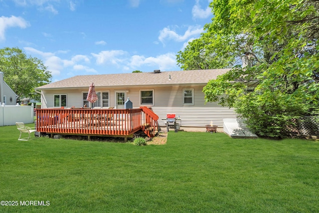 rear view of house with a wooden deck, a shingled roof, and a chimney