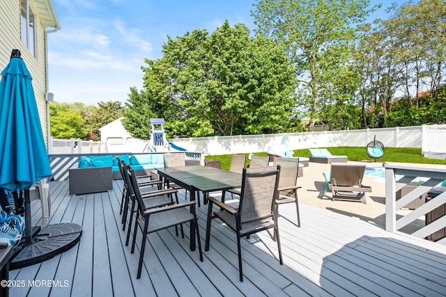 16 Bridle Dr, West Long Branch, NJ 07764 - wooden deck featuring outdoor dining area, a fenced backyard, view of scattered trees, and a playground