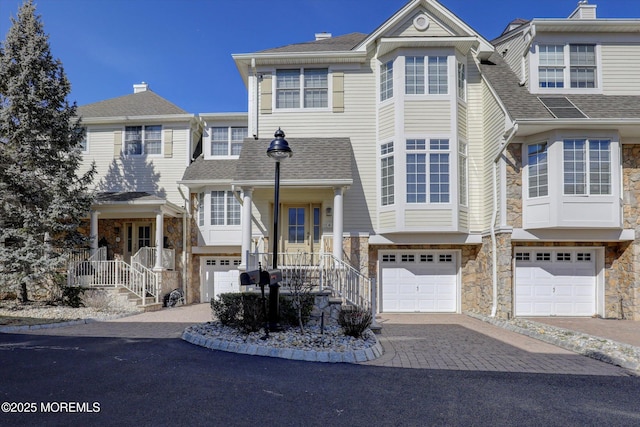 6 Tower Rd, Long Branch, NJ 07740 - view of property with stone siding, a garage, decorative driveway, and a shingled roof